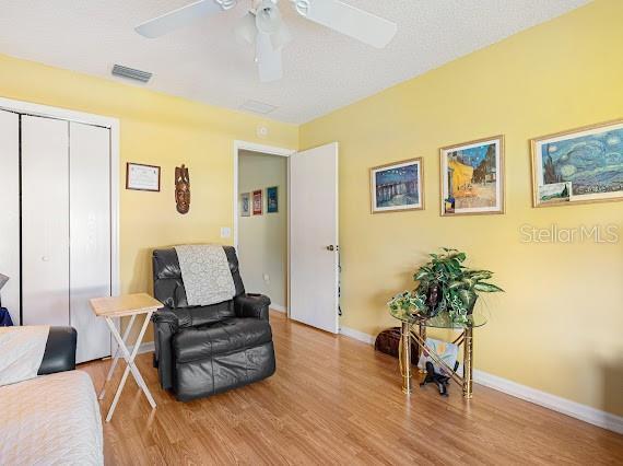 sitting room with light hardwood / wood-style floors and ceiling fan