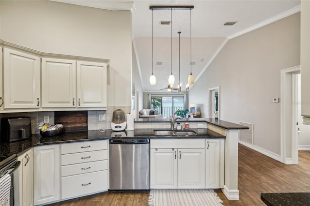 kitchen featuring kitchen peninsula, stainless steel appliances, tasteful backsplash, lofted ceiling, and sink