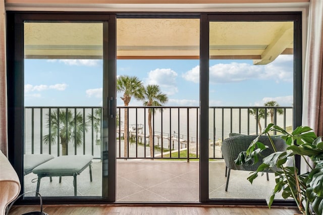 doorway with a water view and hardwood / wood-style flooring