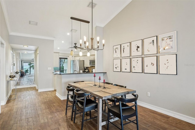 dining room featuring dark hardwood / wood-style flooring, an inviting chandelier, and ornamental molding