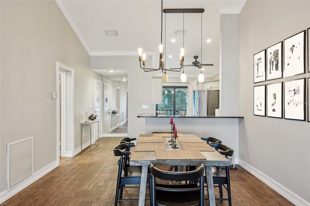 dining space featuring ceiling fan with notable chandelier, crown molding, and hardwood / wood-style flooring