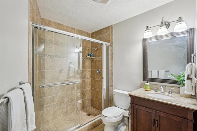 bathroom with a textured ceiling, an enclosed shower, vanity, and toilet