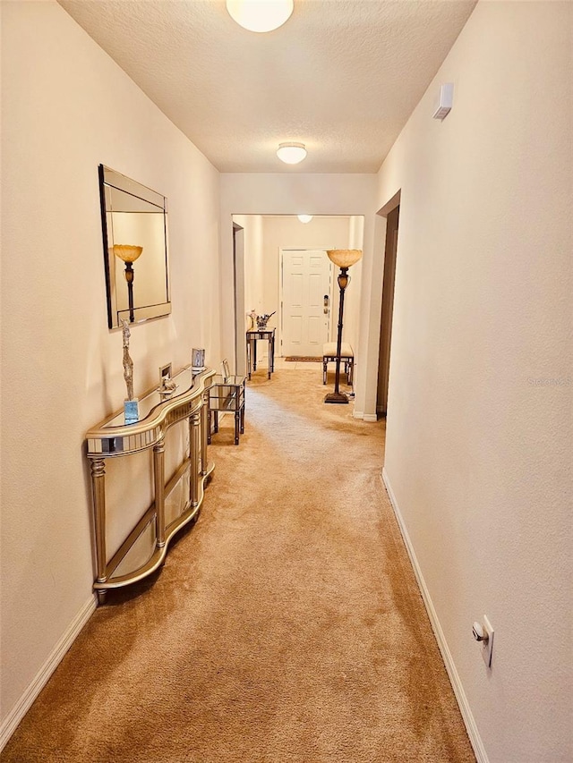 hallway featuring carpet floors and a textured ceiling