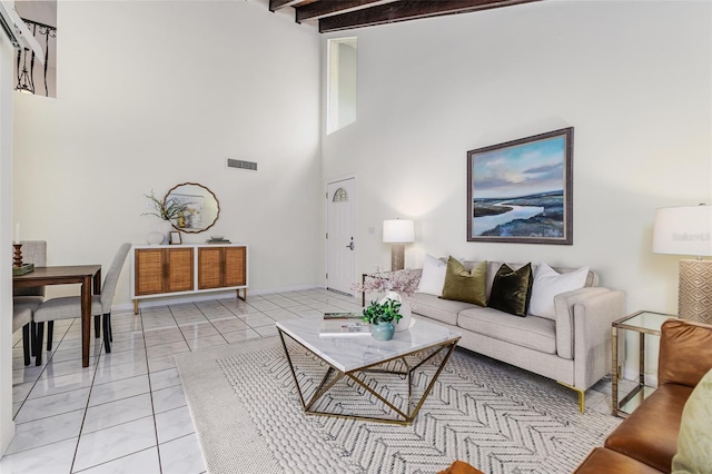 living room with a towering ceiling, beamed ceiling, and light tile patterned floors