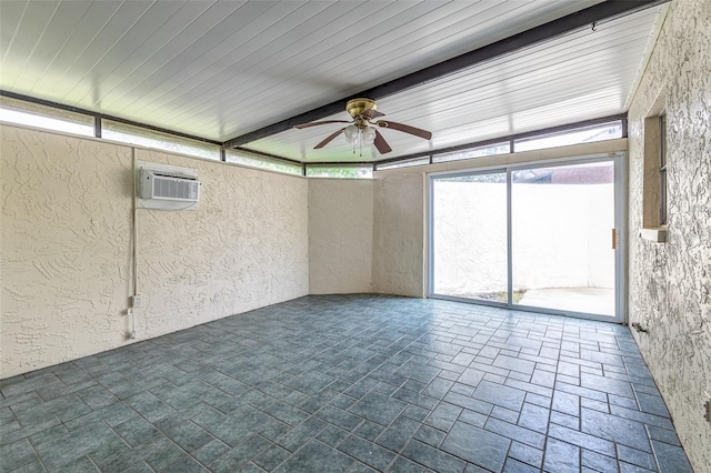 unfurnished sunroom featuring ceiling fan and a wall unit AC