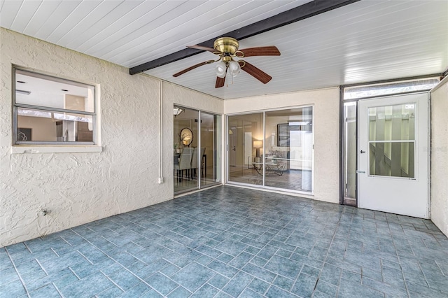 unfurnished sunroom with ceiling fan and wooden ceiling