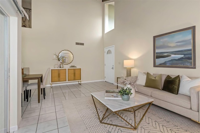 tiled living room featuring a towering ceiling