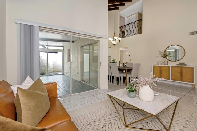 living room with light tile patterned floors, a towering ceiling, and a chandelier