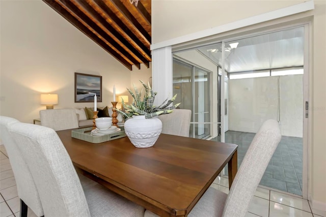 tiled dining space featuring vaulted ceiling with beams