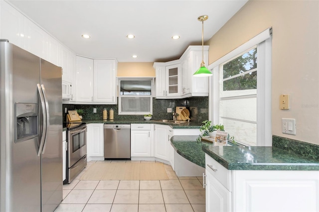 kitchen featuring kitchen peninsula, stainless steel appliances, white cabinetry, and decorative light fixtures