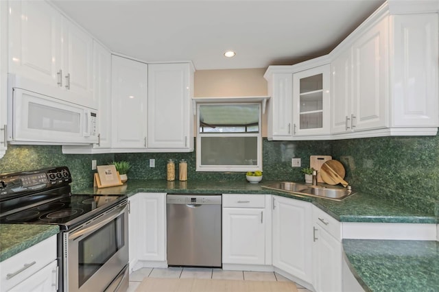 kitchen with light tile patterned flooring, stainless steel appliances, white cabinets, and sink