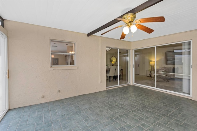 interior space featuring ceiling fan and beamed ceiling