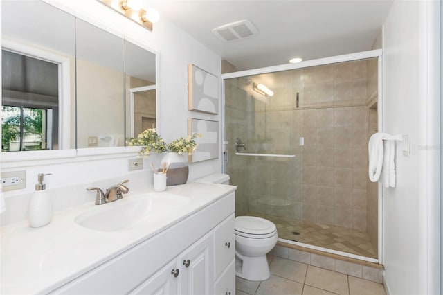 bathroom featuring toilet, vanity, tile patterned floors, and a shower with shower door