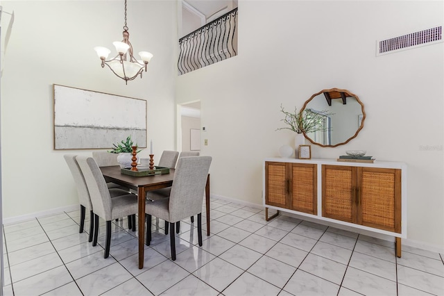 tiled dining area with a towering ceiling and a chandelier