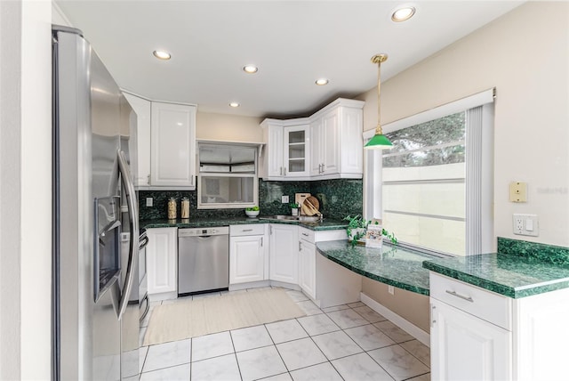 kitchen featuring light tile patterned floors, appliances with stainless steel finishes, white cabinets, and hanging light fixtures