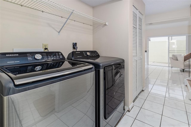 laundry area featuring separate washer and dryer and light tile patterned floors