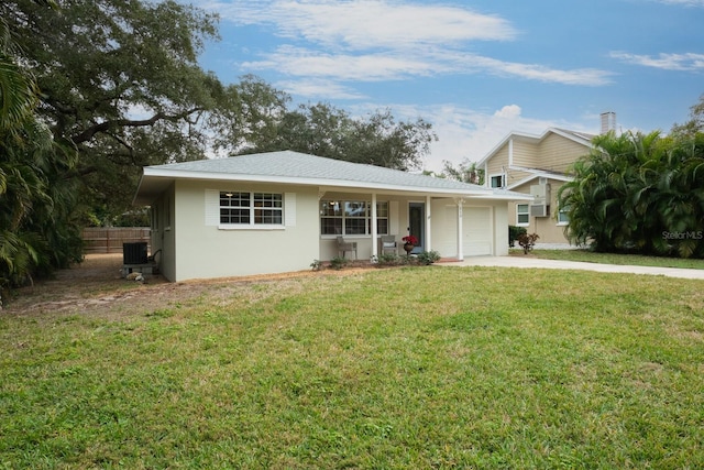 view of front of home featuring central air condition unit, a front lawn, and a garage