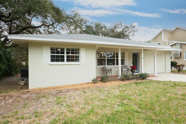 view of front facade featuring covered porch, a front lawn, and a garage