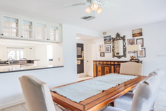 dining room featuring ceiling fan, light tile patterned floors, and sink