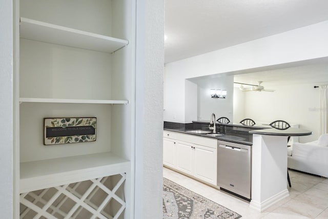 kitchen featuring dishwasher, light tile patterned floors, white cabinetry, ceiling fan, and sink