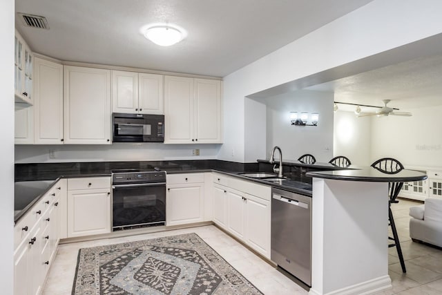 kitchen featuring sink, white cabinetry, stainless steel dishwasher, and kitchen peninsula