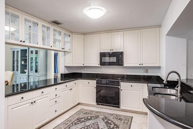 kitchen with sink, white cabinetry, kitchen peninsula, dark stone counters, and electric stove