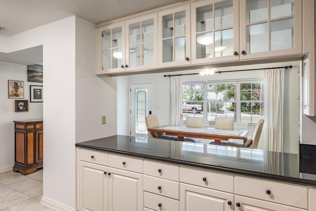 kitchen with white cabinetry and light tile patterned flooring