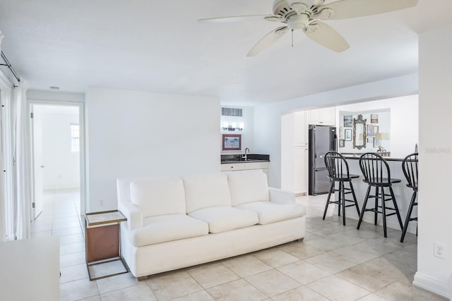 living room featuring indoor wet bar, ceiling fan, and light tile patterned floors