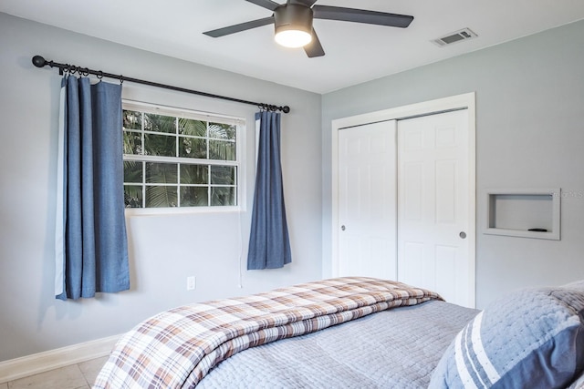 tiled bedroom featuring ceiling fan and a closet