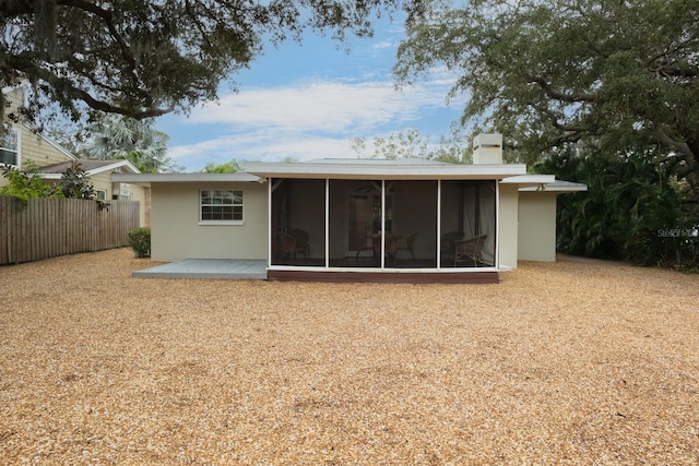 rear view of property featuring a patio and a sunroom