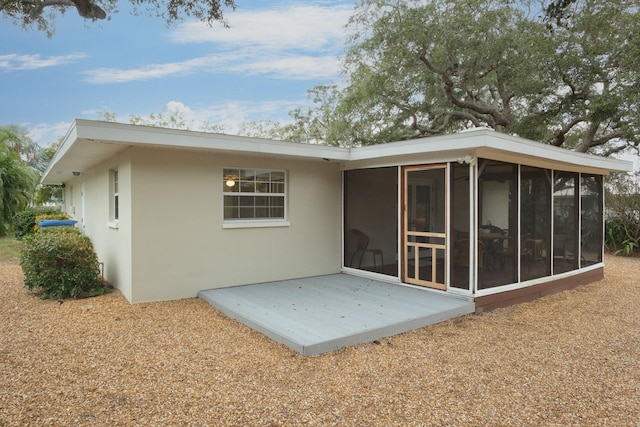 rear view of house featuring a sunroom