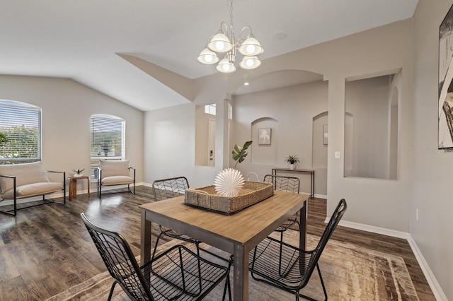 dining room featuring lofted ceiling, dark wood-type flooring, and a notable chandelier