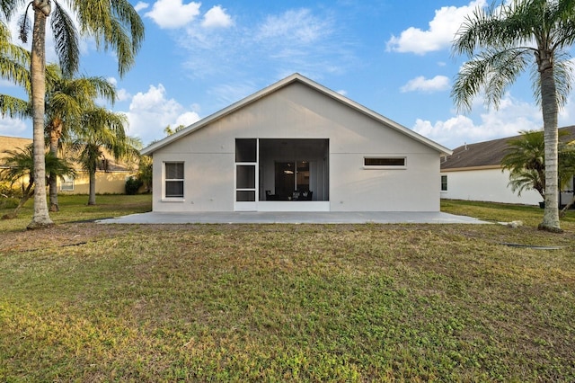 rear view of house featuring a patio area and a yard