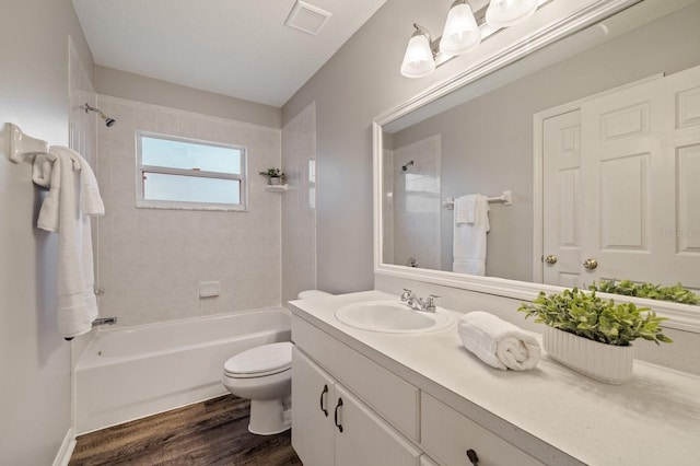 full bathroom featuring toilet, a textured ceiling, tiled shower / bath combo, wood-type flooring, and vanity