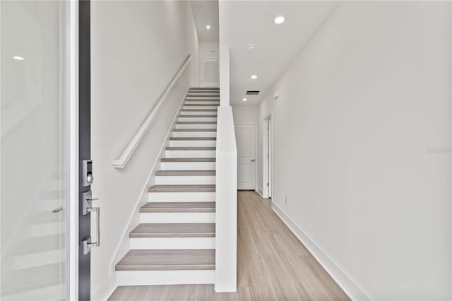 staircase with hardwood / wood-style floors