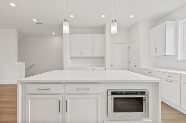 kitchen featuring white cabinetry, a center island, and stainless steel oven