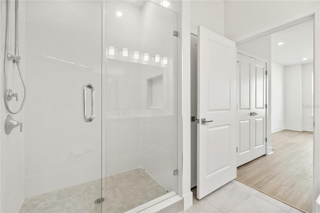 bathroom featuring a shower with shower door and tile patterned floors