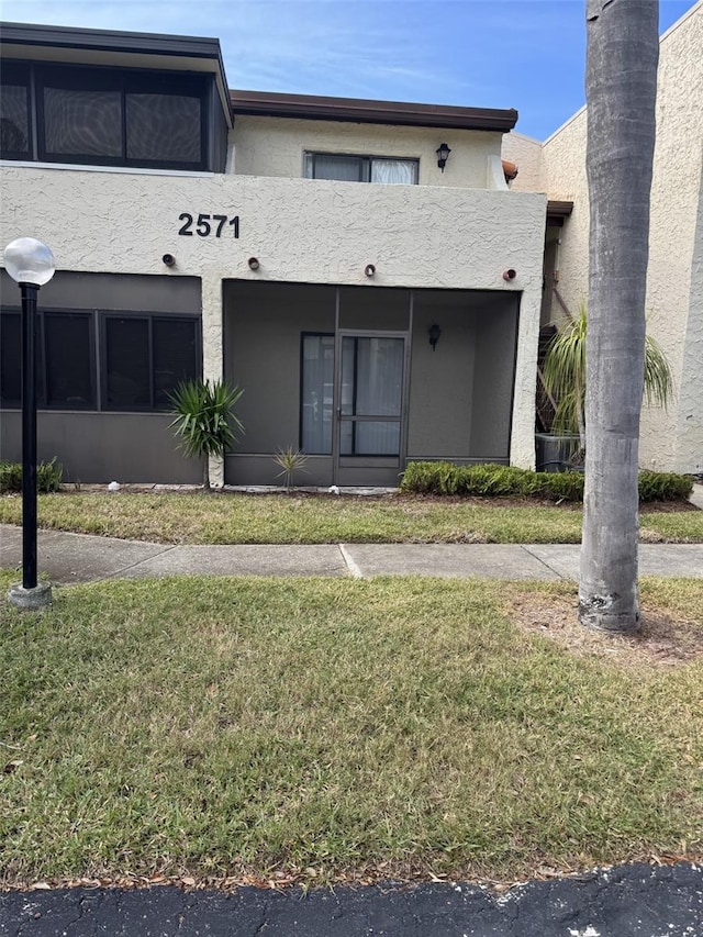 view of front facade featuring a front lawn and a balcony