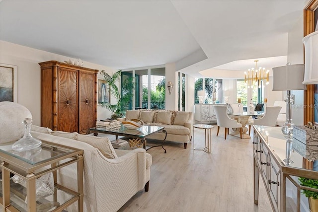 living room featuring a notable chandelier, a wealth of natural light, and light hardwood / wood-style floors