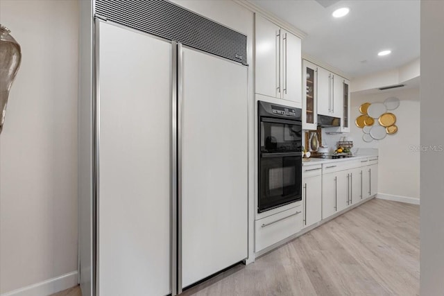 kitchen featuring white cabinetry, light wood-type flooring, and black appliances