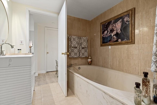 bathroom featuring vanity and a tub to relax in