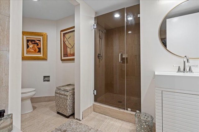 bathroom featuring a shower with door, vanity, tile patterned floors, and toilet