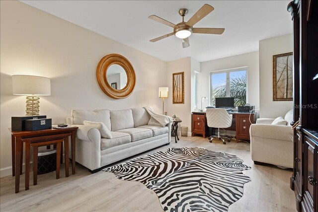 living room with light hardwood / wood-style flooring and ceiling fan