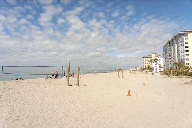 view of community with volleyball court, a beach view, and a water view