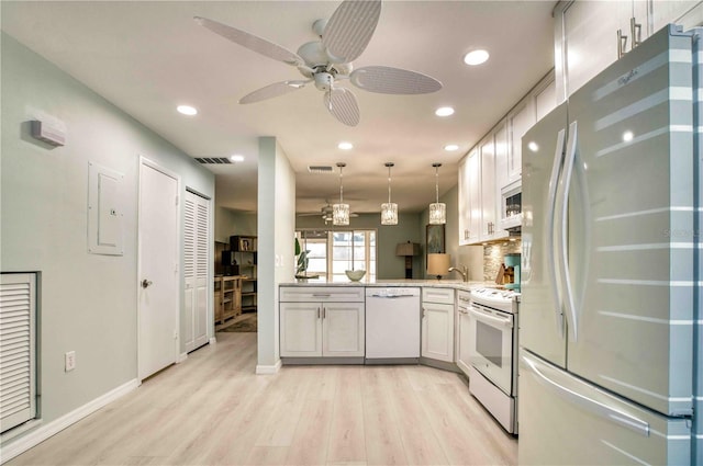 kitchen with pendant lighting, white appliances, light hardwood / wood-style flooring, white cabinets, and kitchen peninsula