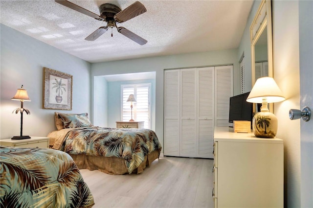 bedroom featuring ceiling fan, a textured ceiling, light hardwood / wood-style floors, and a closet