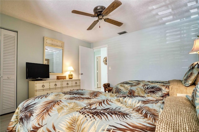 bedroom with ceiling fan, wood-type flooring, a textured ceiling, and a closet