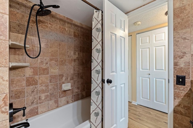 bathroom with a textured ceiling, shower / tub combo, and wood-type flooring