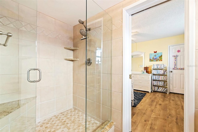 bathroom featuring a textured ceiling, wood-type flooring, and an enclosed shower