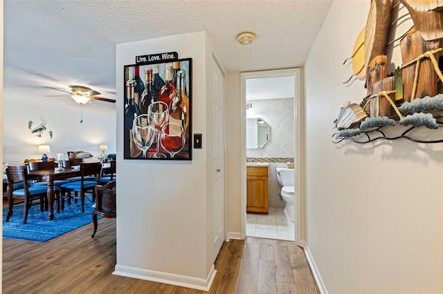 hallway featuring hardwood / wood-style floors and a textured ceiling